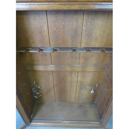 741 - A 19th century oak gun cabinet, with glazed doors opening onto a rack with provision for 6 shotguns.... 