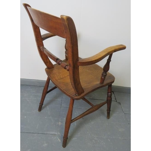 762 - A turn of the century elm and beech open sided armchair, on turned supports with stretchers.
Conditi... 