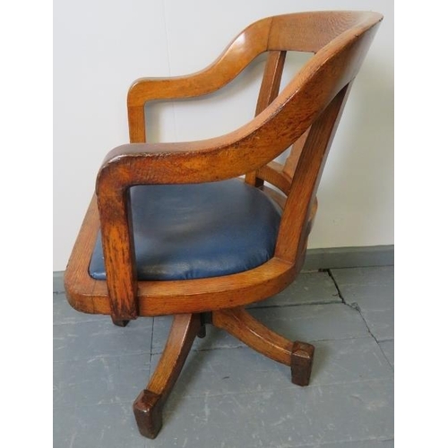 768 - A vintage medium oak swivel desk chair, with seat upholstered in blue leatherette.
Condition report:... 