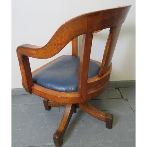 768 - A vintage medium oak swivel desk chair, with seat upholstered in blue leatherette.
Condition report:... 