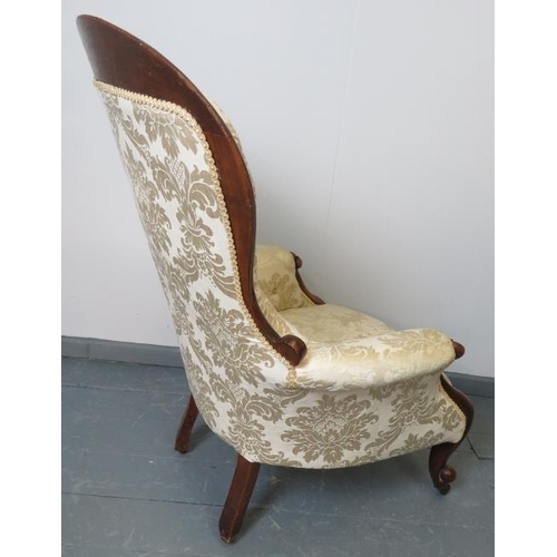 777 - A Victorian mahogany spoonback armchair upholstered in buttoned cream damask, with scrolled armrests... 