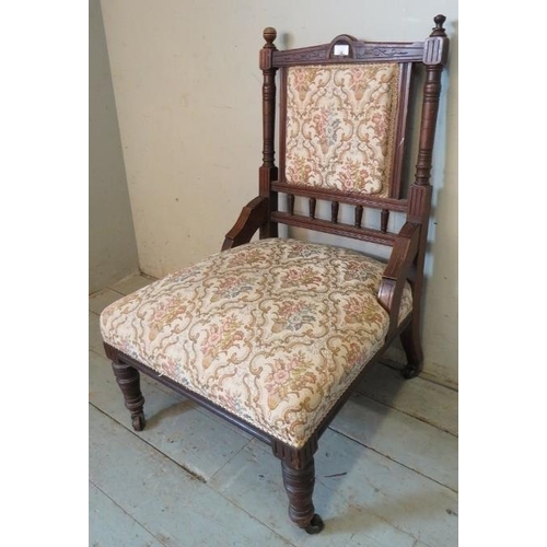 779 - An Edwardian mahogany nursing chair, with tapestry seat, on turned supports with ceramic castors. 
C... 