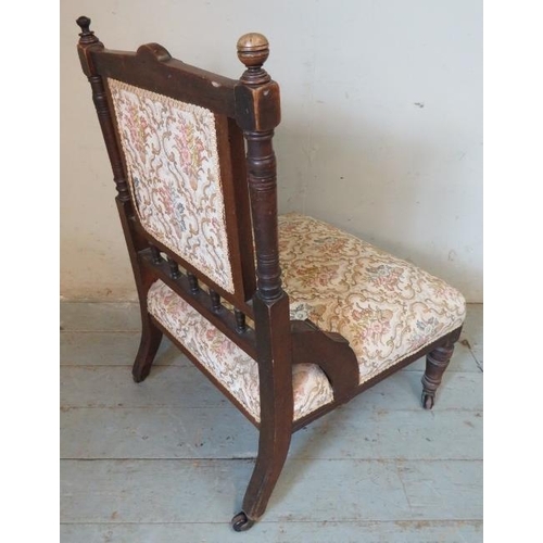 779 - An Edwardian mahogany nursing chair, with tapestry seat, on turned supports with ceramic castors. 
C... 