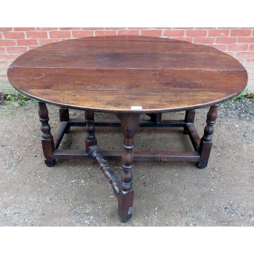 784 - A large 18th Century oak oval gateleg dining table, raised on turned and block supports united by st... 