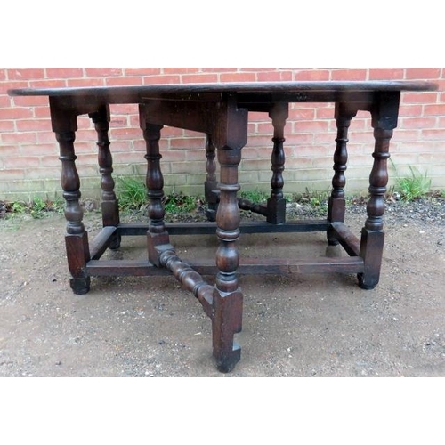 784 - A large 18th Century oak oval gateleg dining table, raised on turned and block supports united by st... 