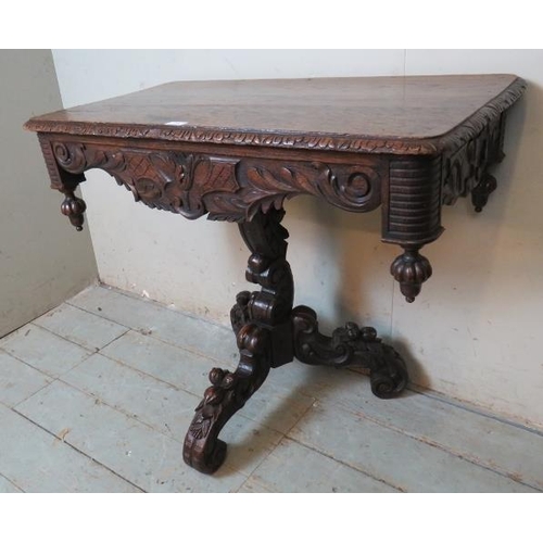 785 - A 19th Century oak pedestal table, ornately carved in the Flemish taste, the foliate carved and shap... 