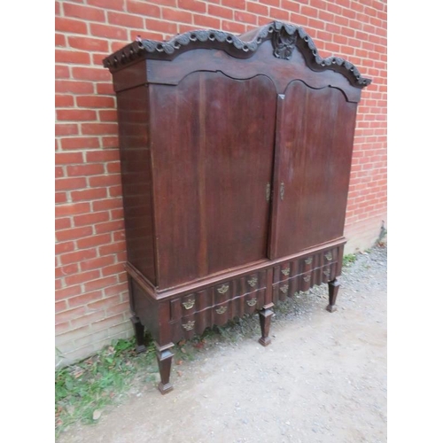 800 - An 18th century Spanish oak linen press with ornately carved pierced shaped cornice over twin cupboa... 