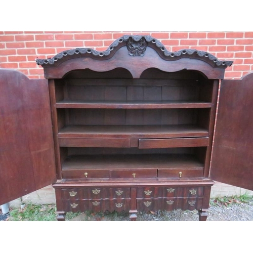 800 - An 18th century Spanish oak linen press with ornately carved pierced shaped cornice over twin cupboa... 