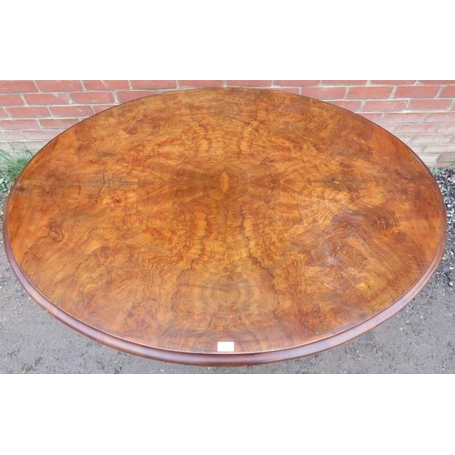 802 - A Victorian walnut oval tilt top loo table, the quarter veneered top raised on a bulbous octagonal c... 