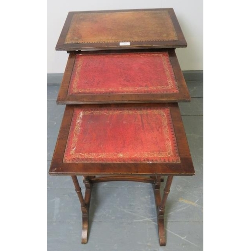 805 - An Edwardian style mahogany nest of three tables with gilt tooled red leather inserts, on faux bambo... 