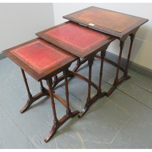 805 - An Edwardian style mahogany nest of three tables with gilt tooled red leather inserts, on faux bambo... 