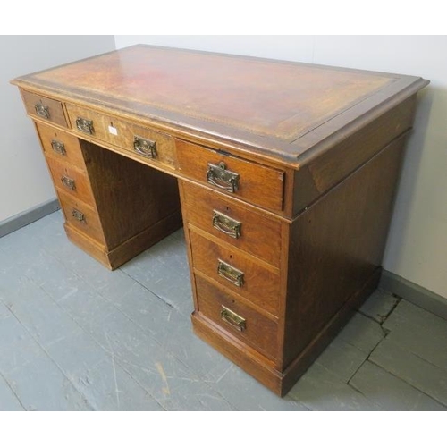 814 - A Victorian oak kneehole pedestal desk, with inset gilt tooled leather writing surface, housing a co... 