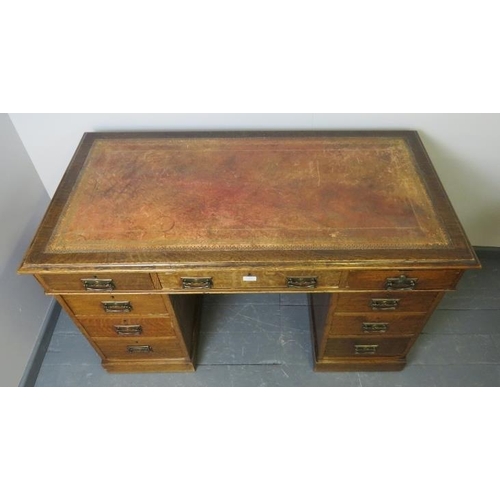 814 - A Victorian oak kneehole pedestal desk, with inset gilt tooled leather writing surface, housing a co... 