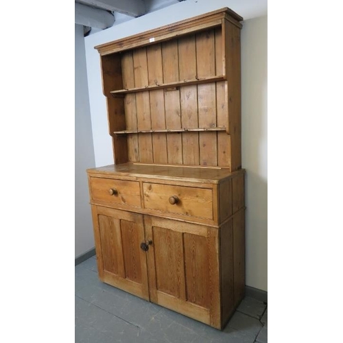 820 - An antique stripped pine kitchen dresser with plate rack shelving and two short drawers over a cupbo... 