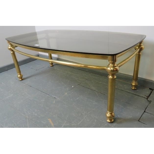 832 - A contemporary coffee table with smoked glass top, on polished brass base.
Condition report: No issu... 