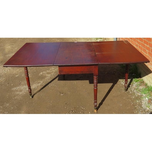 833 - A late Georgian mahogany drop leaf dining table, on tapering turned supports with brass castors. 
Co... 