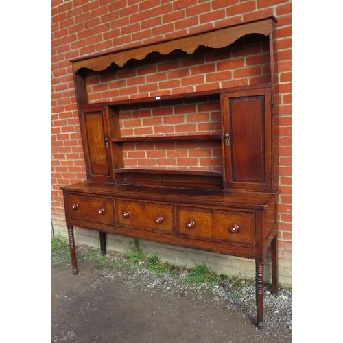 837 - A Georgian oak high back dresser with plate-rack shelving flanked by inlaid cupboards, over a sidebo... 