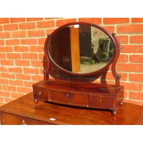 840 - A Georgian mahogany oval swing vanity mirror, the bow fronted box base housing three drawers, on bun... 