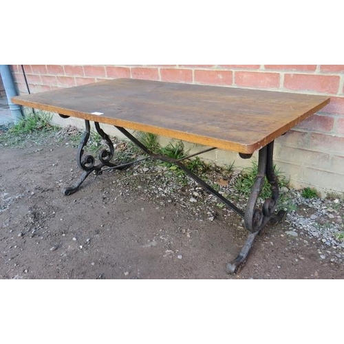 861 - A vintage garden side table with a deep grained medium oak top, on ornate cast iron supports with st... 