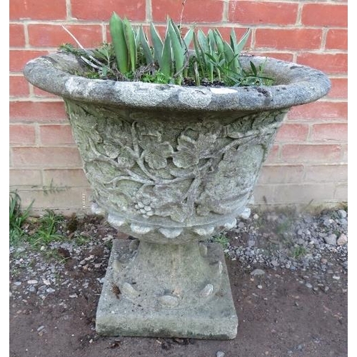 865 - A nicely weathered reconstituted stone garden urn with fruiting vine relief decoration.
Condition re... 