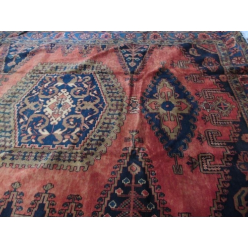 922 - A Persian Vles carpet, blue and taype motifs on a burnt orange/red ground. 380cm x 255cm.
Condition ... 