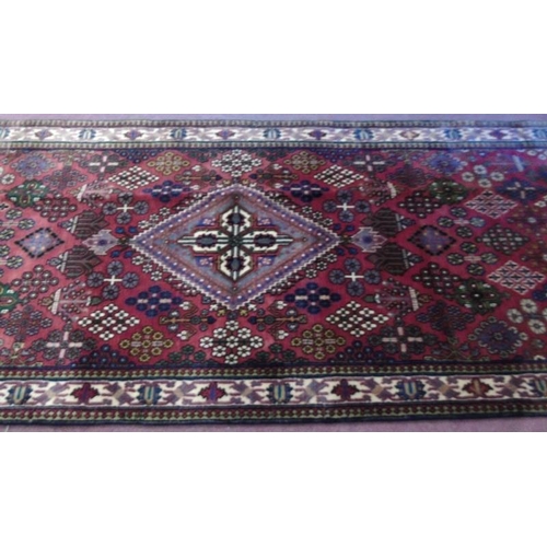 929 - A Persian Melmeh runner on claret ground. 3.90x1.10
Condition report: In very good condition and vib... 