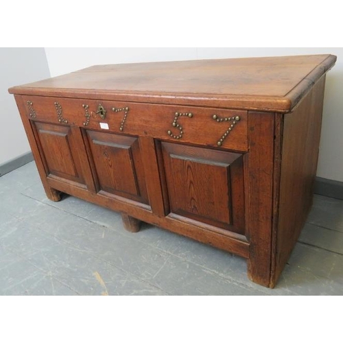 704 - An 18th century medium oak coffer with internal candle box, fielded panels to front and applied bras... 
