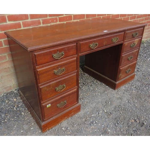 734 - An Edwardian mahogany kneehole desk, housing a configuration of nine graduated drawer, with fancy br... 