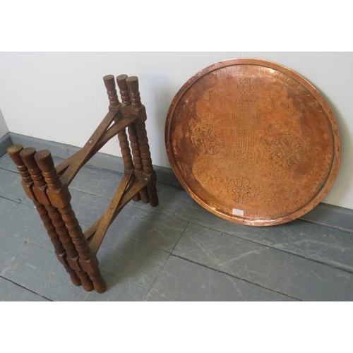 762 - An Islamic brass topped Benares style table, featuring hand tooled designs, on folding ball turned o... 