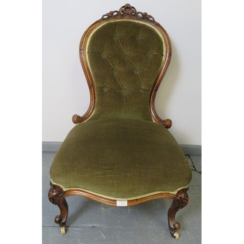 765 - A Victorian walnut spoonback nursing chair, with ornately carved and pierced cornice, upholstered in... 