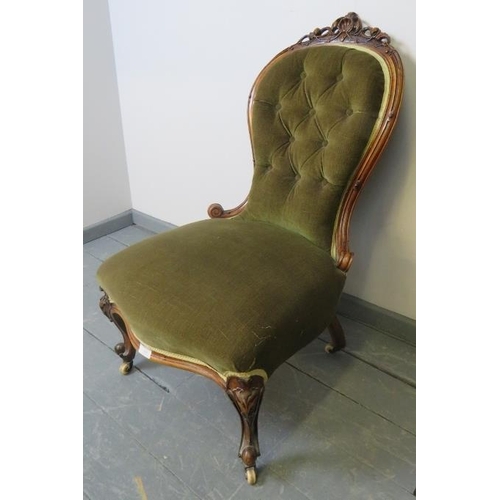 765 - A Victorian walnut spoonback nursing chair, with ornately carved and pierced cornice, upholstered in... 