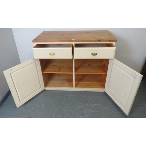 768 - A pine sideboard painted cream with stripped top, housing two short drawers over two cupboards, all ... 
