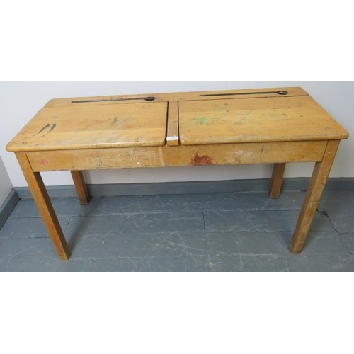 787 - A vintage beech double school desk, with individual rising lids, on square supports. 
Condition repo... 