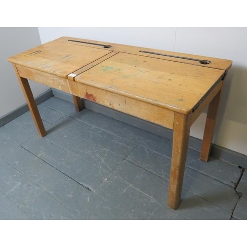 787 - A vintage beech double school desk, with individual rising lids, on square supports. 
Condition repo... 