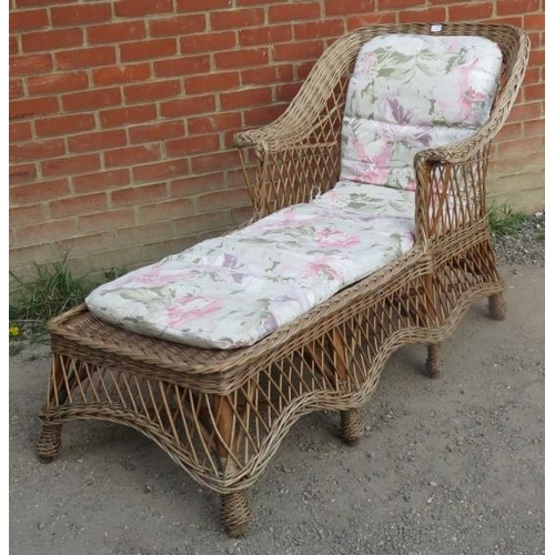 720 - A vintage wicker chaise long, with shaped backrest and apron, raised on eight supports bound with br... 