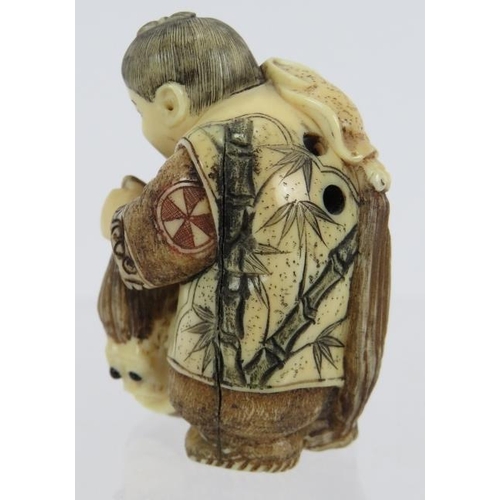 11 - A very finely carved Japanese ivory Netsuke, Meiji period, of a man pulling a creature from a basket... 