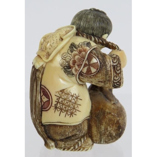 11 - A very finely carved Japanese ivory Netsuke, Meiji period, of a man pulling a creature from a basket... 