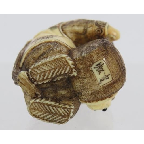 11 - A very finely carved Japanese ivory Netsuke, Meiji period, of a man pulling a creature from a basket... 