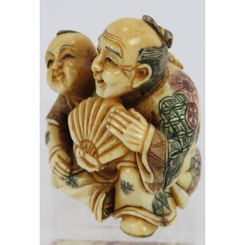 12 - A very finely carved Japanese ivory Netsuke, Meiji period of a man with child holding a fan decorate... 