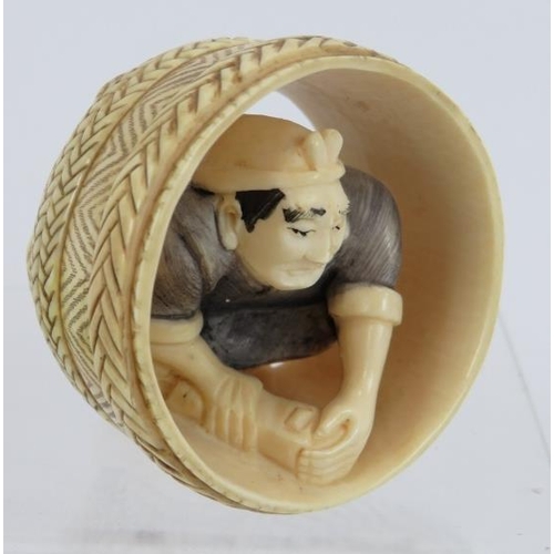 15 - A finely carved Japanese ivory Netsuke of a cooper working in a barrel. Height: 4.8cm.  Signed to ba... 