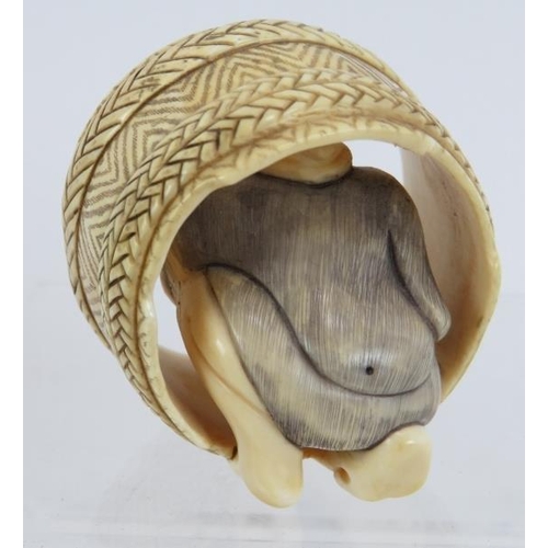 15 - A finely carved Japanese ivory Netsuke of a cooper working in a barrel. Height: 4.8cm.  Signed to ba... 