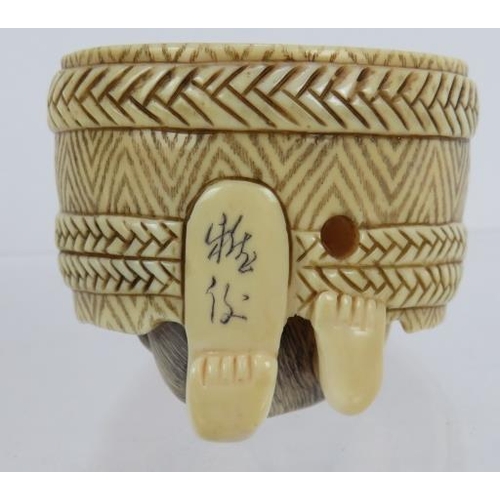 15 - A finely carved Japanese ivory Netsuke of a cooper working in a barrel. Height: 4.8cm.  Signed to ba... 