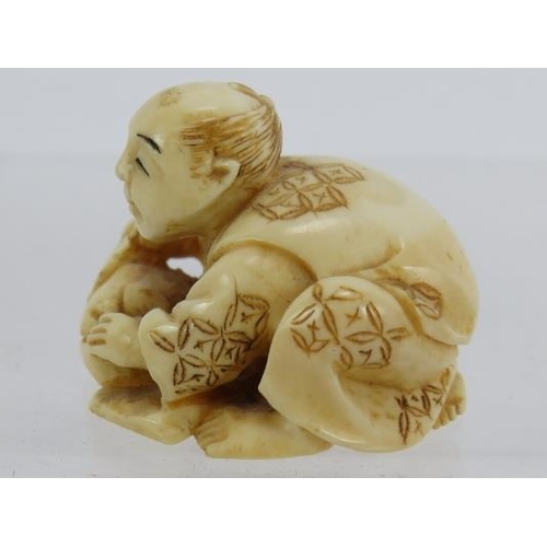 22 - A finely carved Japanese ivory Netsuke, early 20th century of a crouching figure. Height: 2.8cm. sig... 