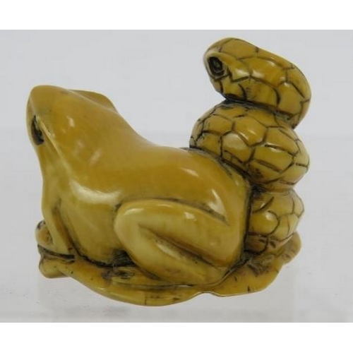 24 - A Japanese carved ivory Netsuke, early 20th century featuring a frog and snake sitting on a lily pad... 