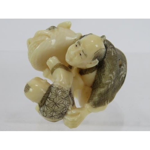 25 - A finely carved Japanese ivory Netsuke, Meiji period, featuring a man and child.  Height: 3.2cm.  Si... 