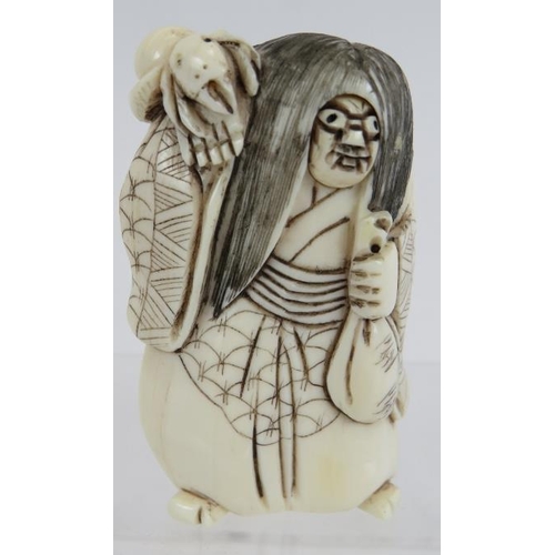 28 - A Japanese carved ivory Netsuke, early 20th century, of a figure with changing face and spider on hi... 