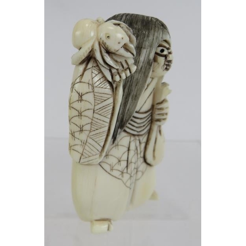 28 - A Japanese carved ivory Netsuke, early 20th century, of a figure with changing face and spider on hi... 