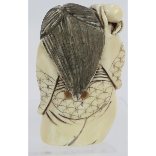 28 - A Japanese carved ivory Netsuke, early 20th century, of a figure with changing face and spider on hi... 