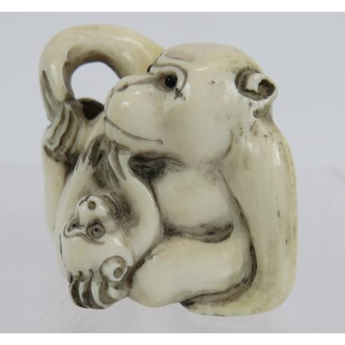 30 - A Japanese carved ivory Netsuke early 20th century, of a monkey and dog. Height: 3.2cm. Signed to ba... 