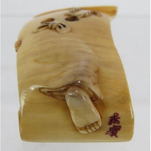 31 - A finely carved Japanese ivory Netsuke, Meiji period, of a semi nude female on a scroll decorated in... 